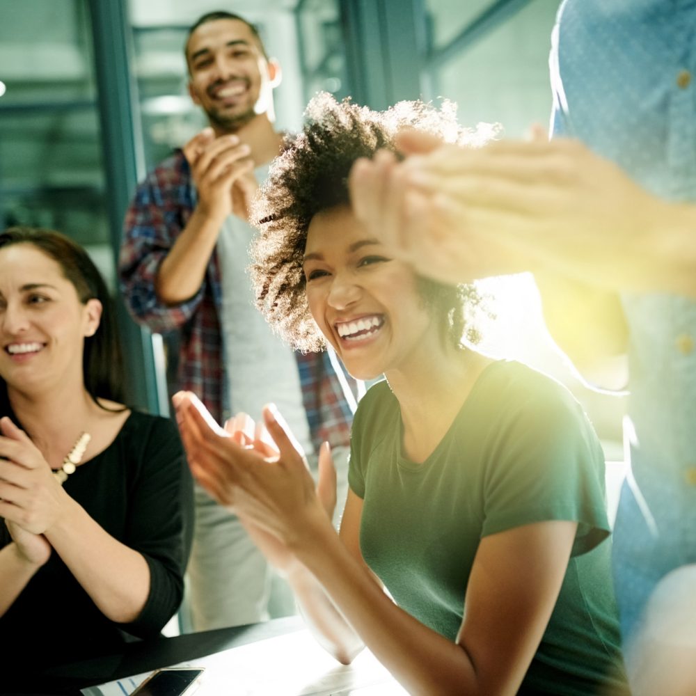 Shot of a team of creative businesspeople applauding an achievement  while working late in the boardroom